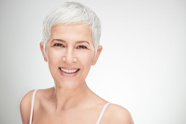 Senior woman with cropped hair and great skin smiling at the camera