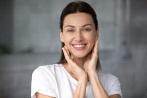 image of smiling woman holding her jawline