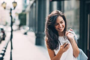 woman smiling on cell phone after chin augmentation