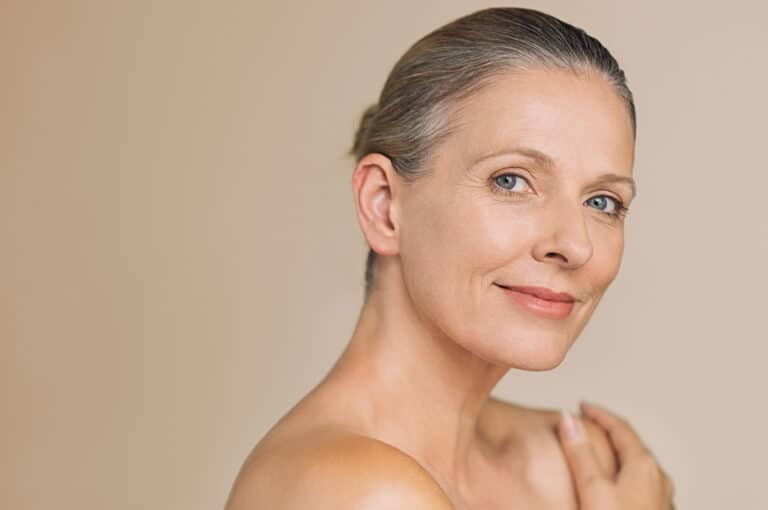 Smiling,Senior,Woman,With,Bun,Hair,And,Hand,On,Naked