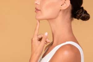 Woman displaying a defined jawline and neck contour after plastic surgery.